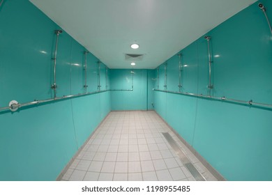 Wide Angle Image Of A Shower Designed For Multiple People, The Shower Shows Shower Heads With A Tiled Floor.