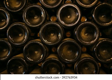 Wide angle image of a stack of wine bottles in an old dark wine cellar. Natural available light only.