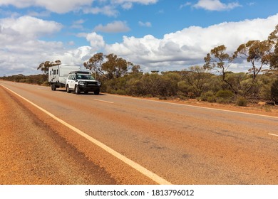 Wide Angle Landscape View Of 4WD And Modern Caravan On An Outback Highway In Australia
