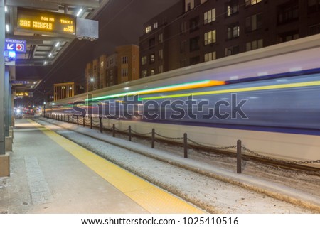 A Wide Angle Long Exposure of a Train Passing a Lightrail Platform in the Twin Cities Metro Area at Night