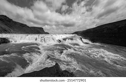 Wide angle panorama of big Gullfoss waterfalls in Iceland. Black and white scenery with tourist attraction and natural wonder on the Golden Circle. Dramatic pristine landscape with powerful cascade. - Powered by Shutterstock