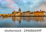 Wide angle panorama of Regensburg with old town, cathedral, church and Stone Bridge on the Danube, picturesque sunset