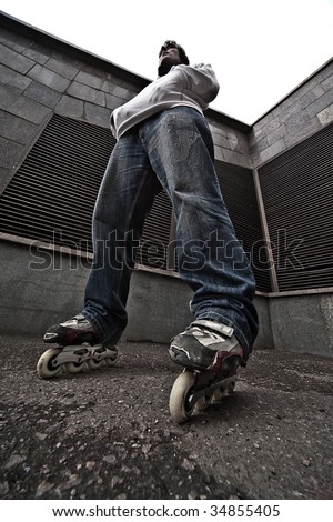 Wide angle portrait of a serious rollerskating man