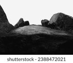 A Wide Angle of a Rock for a Product Display, Showing a Large Dark Blurred Foreground with intentional Focus to the Middle Top Surface of the Boulder with Close Natural Texture.