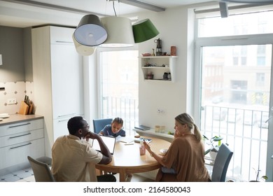 Wide Angle Scene On Multiethnic Family At Dinner Table In Kitchen, Copy Space