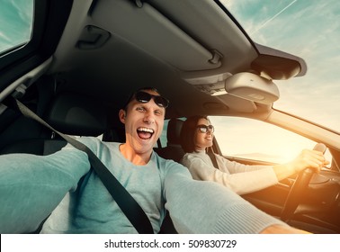 Wide angle selfie of funny Couple drive in car - Powered by Shutterstock