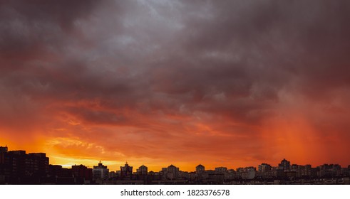 Wide Angle Shot Of Dramatic Stormy Sunset Sky With Clouds Over City Skyline Background.