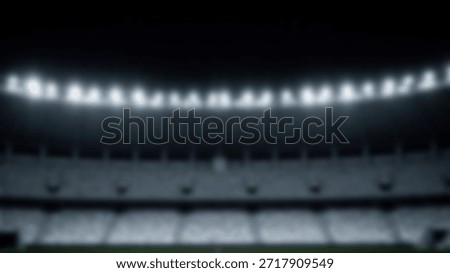 Wide angle shot of an empty stadium at night with bright floodlights illuminating the seats.