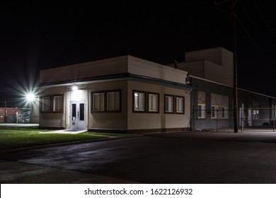 Wide Angle Shot Of Generic Small Office Building In An Industrial Park At Night With Green Grass And Star Burst Lights With Clear Sky In Dayton Ohio