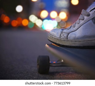 wide angle shot of a guy getting ready to skate down an empty urban street in a dark city toned with a retro vintage instagram filter app or action effect