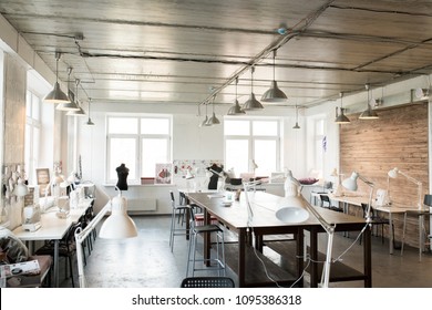 Wide Angle Shot Of Modern Atelier Interior With Wooden Workstation In Foreground And Sewing Dummies, No People, Copy Space Background