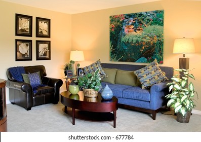 Wide Angle Shot Of A Modern Living Room Consisting Of Couches, Chairs, Coffee Table, Lamps & Photos