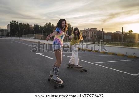 Similar – Young man riding on skate and holding surfboard