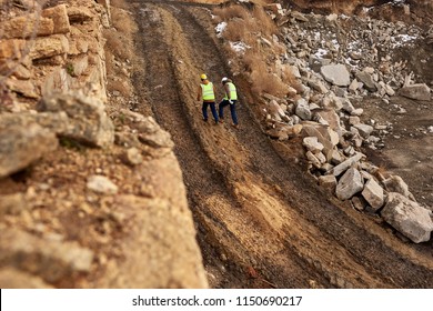 Wide Angle Shot Of Two Industrial  Workers Wearing Reflective Jackets Walking In Dirt On Mining Worksite, Copy Space