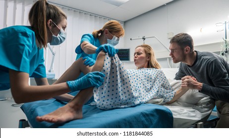 Wide Angle Shot of a Woman in Labor Pushes to Give Birth, Obstetricians Assisting, Spouse Holds Her Hand. Modern Maternity Hospital/ Delivery Ward with Professional Midwives. - Shutterstock ID 1181844085