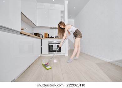 Wide Angle Shot Of Young Housewife Cleaning Floor In Apartment, Washing Mopping Kitchen Floor With Damp Mop And Detergent, Female Doing Household Chores. Housework And Housekeeping