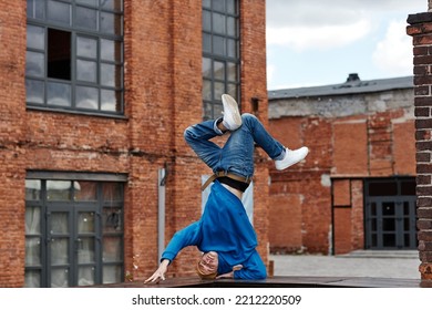 Wide Angle Shot Of Young Man Doing Handstand Breakdance Pose In Urban Factory Setting, Copy Space