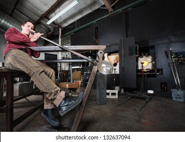 Wide Angle View Of Artisan Blowing Into Fine Art Glass