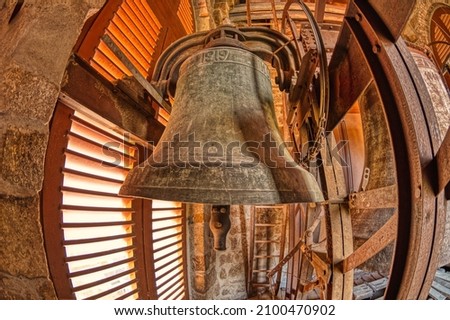 Wide angle view of a bell tower in a church. In the foreground you can see a bell from 1919.