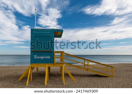 Wide angle view of a blue and yellow wooden lifeguard hut on the beach in Fuengirola (Malaga, Spain)