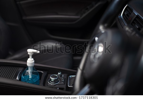 Wide angle view of bottle of blue sanitizer\
ethyl alcohol hand gel cleanser put in the car, prepare for\
protecting coronavirus, COVID19\
