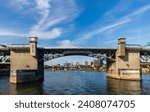 Wide angle view of Burnside Bridge and blue water of the Willamette River in Portland, Oregon, on a beautiful deep blue sky autumn afternoon.