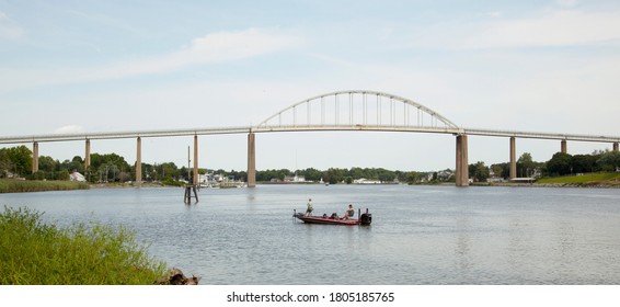 Wide Angle View Of The Chesapeake And Delaware Canal (C And D Canal) At The Back Creek Section In Chesapeake City, MD. An Old Metal Arched Bridge Is On The Canal.  A Couple Is Fishing On A Boat