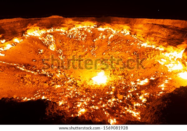 Wide angle view of Darvaza Gas Crater flames in\
Turkmenistan, Central Asia at night. Natural gas field\
intentionally set on fire by geologists. Also referred as the Door\
to Hell or Gates of Hell.