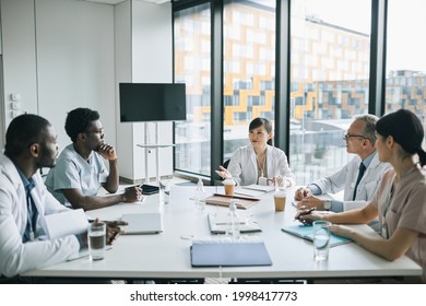 Wide Angle View At Diverse Group Of Doctors Sitting At Meeting Table In Conference Room During Medical Seminar, Copy Space