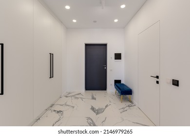 Wide angle view of the entrance to the apartment with white interior and marble floor. High quality photo