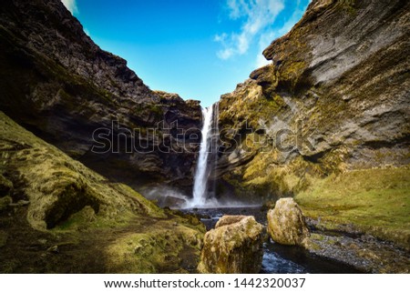 a wide angle view of giant water fall Kvernufoss