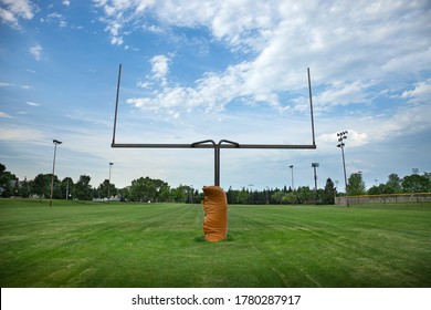 Wide angle view of a goalpost on a football field with beautiful clouds in the morning