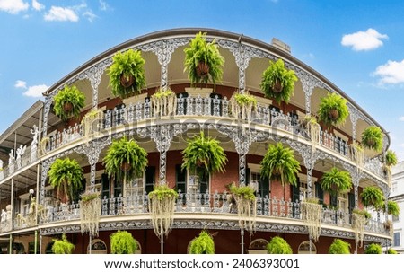 Wide angle view of hanging baskets on tradional New Orleans building in the French Quarter with grey wrought iron balconies