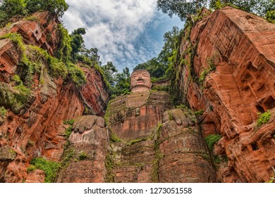 Wide Angle View Of The Leshan Giant Buddha In Sichuan Province China. Perspective From Below Looking Up. Summer Day With No People And Blue Sky.