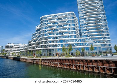 Wide angle view of the Lighthouse complex in Aarhus, Denmark, showcasing the main building with modern glass architecture on the waterfront skyline.