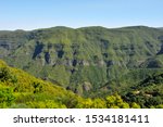 Wide angle view looking down a valley in the mountains with lush green vegetation