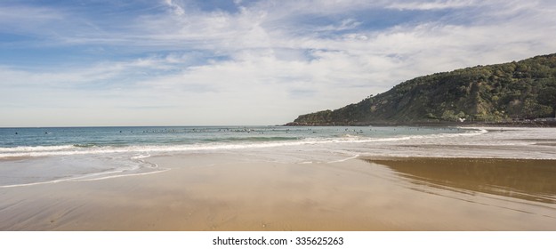 Wide angle view of many surfers in the Beach of San Sebastian, Spain