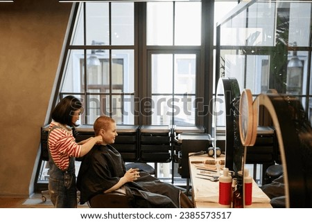 Wide angle view of modern loft style beauty salon with tall glass windows, copy space