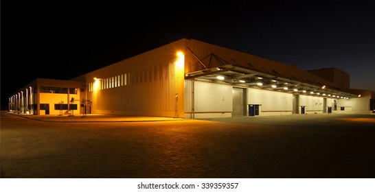 wide angle view of a modern warehouse at night in flood light light