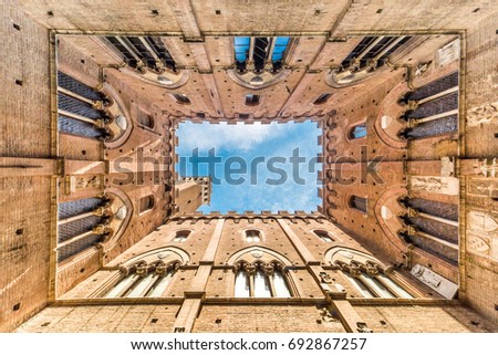 Wide angle view on the La Torre del Mangia; picture taken from the ground looking straight up;  Piazza del Campo, Palazzo Pubblico, Siena, Italy.