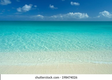 wide angle view of perfect caribbean white sand beach, turquoise waters and blue sky