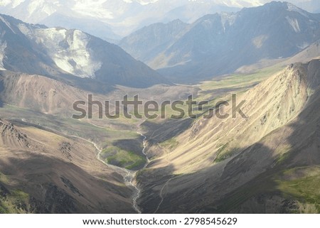 Wide angle view of the rugged terrain and deep valleys of the Zailiysky Alatau.