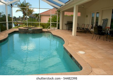 Wide Angle View Of Screened In Pool And Lanai In Florida With Sitting Area