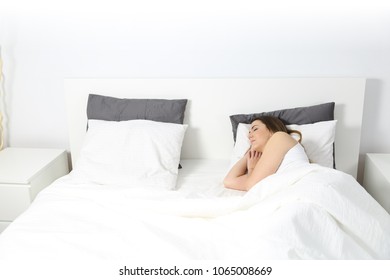 Wide Angle View Of A Woman Sleeping In A Bed At Home With An Isolated White Wall In The Background Above