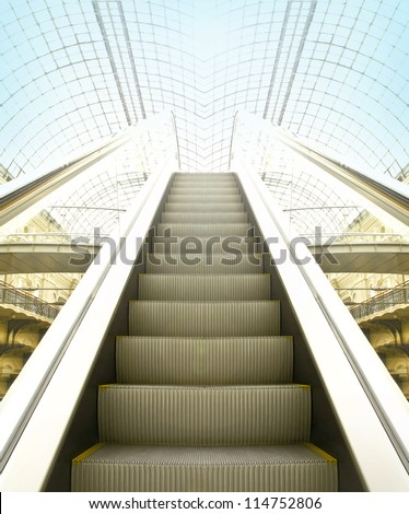Wide angled view to perspective escalators stairway inside contemporary blue glass business centre, concept of successful career elevation