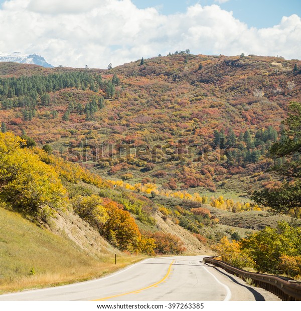 Wide asphalt mountain road in beautiful sunny autumn,\
Colorado, USA