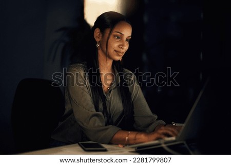 Wide awake and still very productive. a young businesswoman working on a laptop in an office at night.