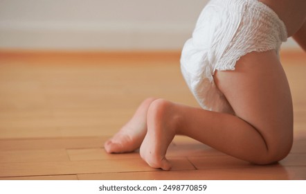 Wide banner photo featuring a close-up of a baby’s bottom in diapers against a wooden background. Ideal for highlighting baby products, diaper promotions, or child care   