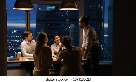 Wide banner view or African American male boss or director head meeting with diverse colleagues in office at night. Multiracial employee work late hours, manage to meet deadline. Teamwork concept. - Powered by Shutterstock