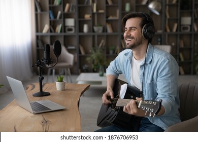 Wide banner view of happy millennial male artist hold guitar take online video webcam lesson on computer. Smiling young man singer or composer use instrument watch music tutorial on laptop at home. - Powered by Shutterstock